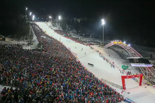 Nachtskilauf mit beleuchteter Piste und Publikum in Schladming